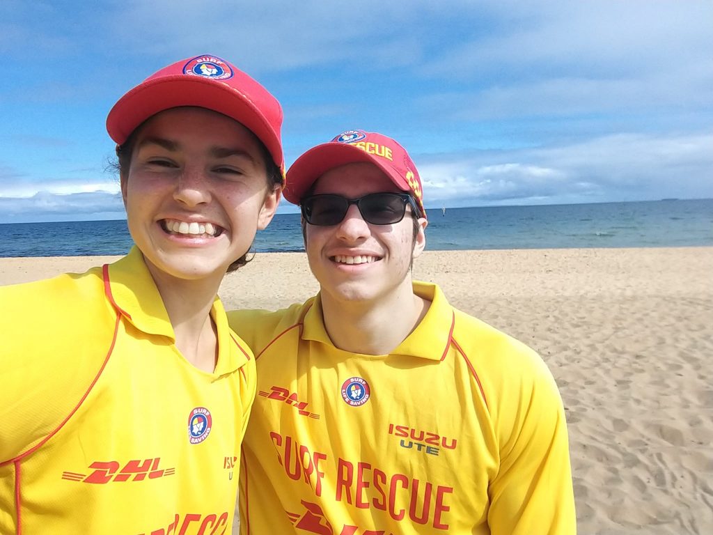 Smiling woman and man in patrol uniform at Sandringham Beach.